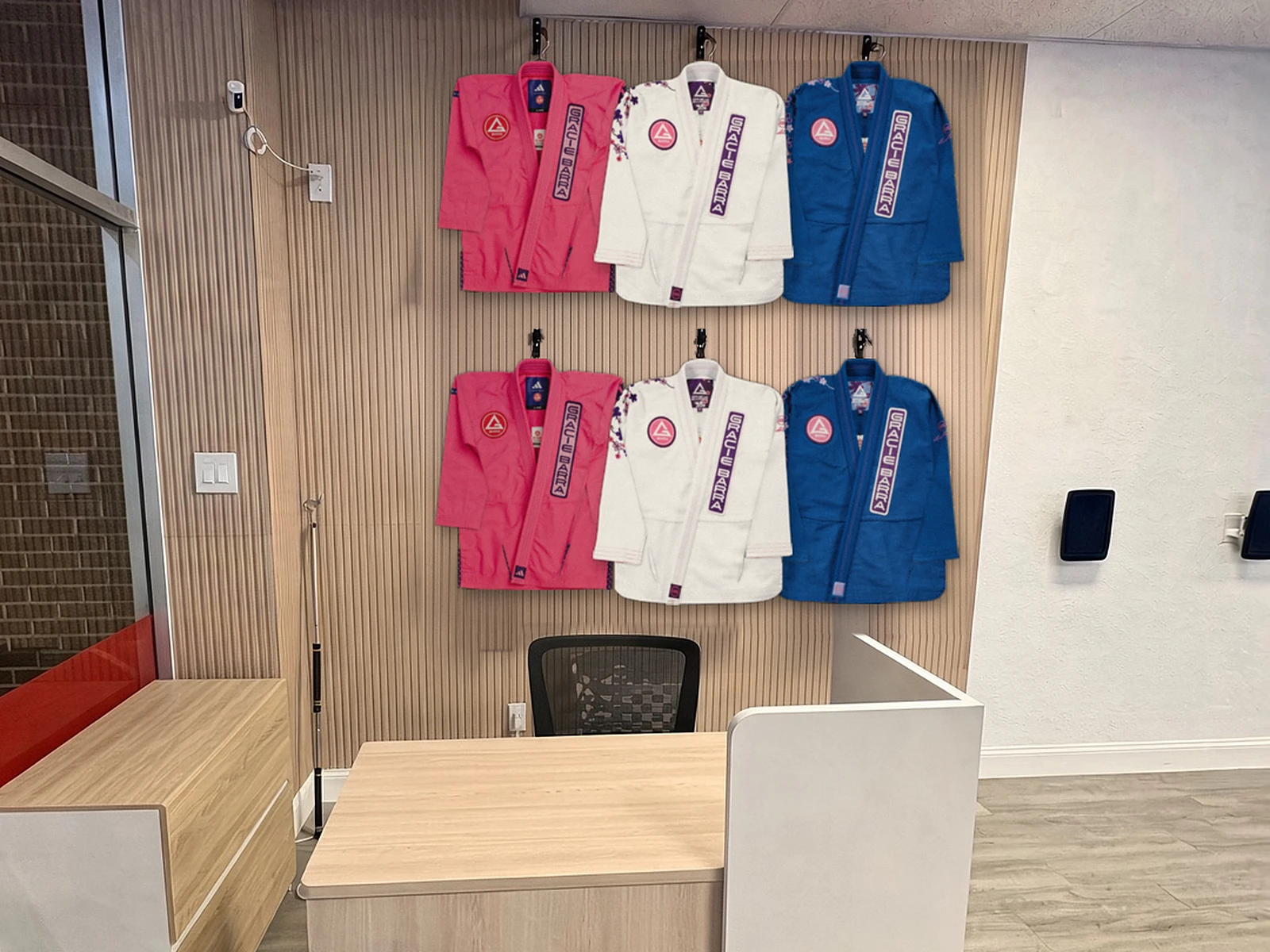 Gracie Barra Coppell pro shop wall with Gracie Barra gis neatly displayed above the front desk
